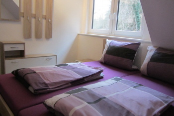 Bettenlager mit Doppelbett und Bettwäsche